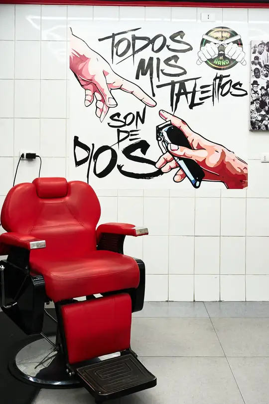 Sillón de barbero rojo frente al mural